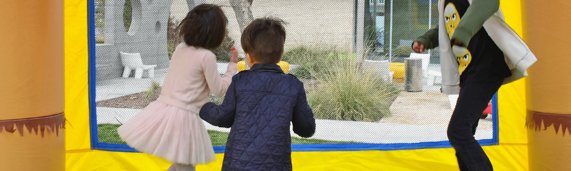 Kids playing in backyard bounce house